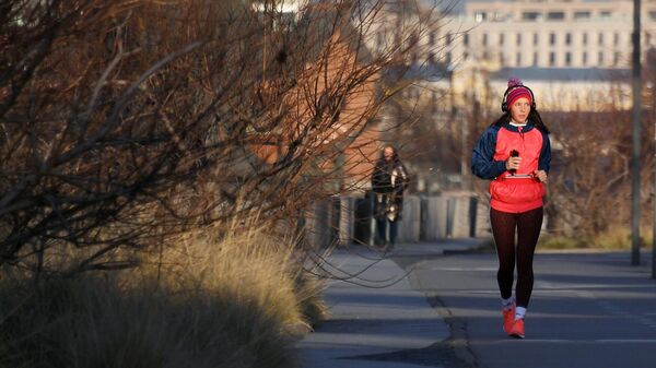 Девушка во время пробежки на Крымской набережной в Москве