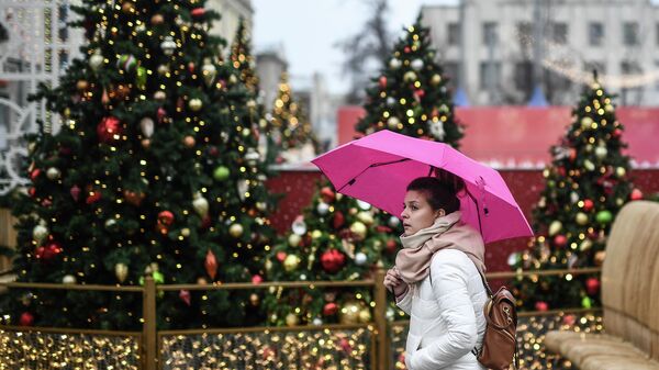 Девушка идет под зонтом по улице Москвы