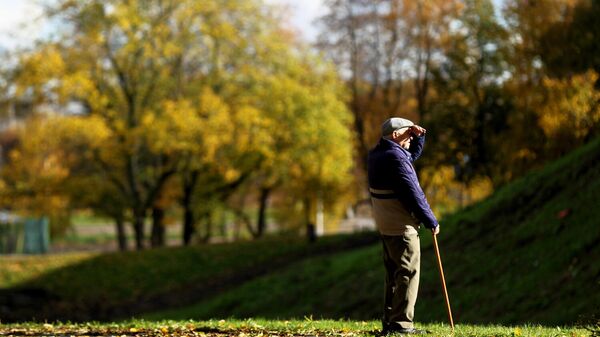 Пожилой мужчина на прогулке в парке