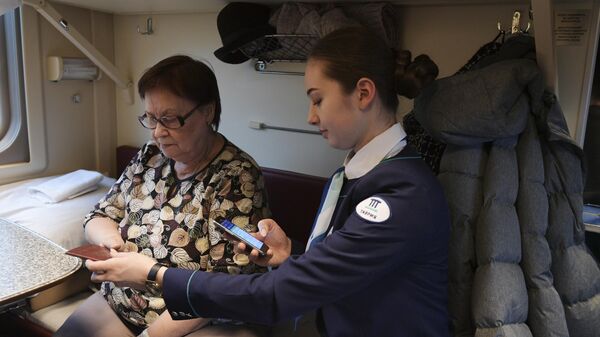 Проводница проверяет билет у пассажирки в поезде Таврия, следующем по маршруту Санкт-Петербург - Севастополь
