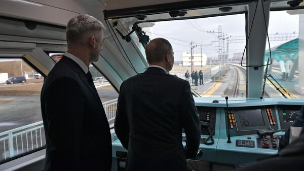 Президент РФ Владимир Путин в кабине машиниста рельсового автобуса, который отправляется в первый рейс по железной дороге Крымского моста