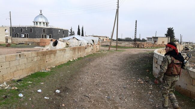 Сирийский ополченец в освобожденном от боевиков поселке Сукейя в провинции Идлиб