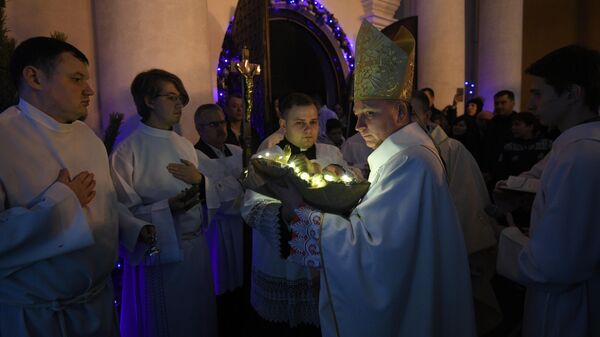 Викарный епископ Юрий Кособуцкий вносит младенца в рождественский вертеп в римско-католическом кафедральном соборе Святого Имени Пресвятой Девы Марии в Минске