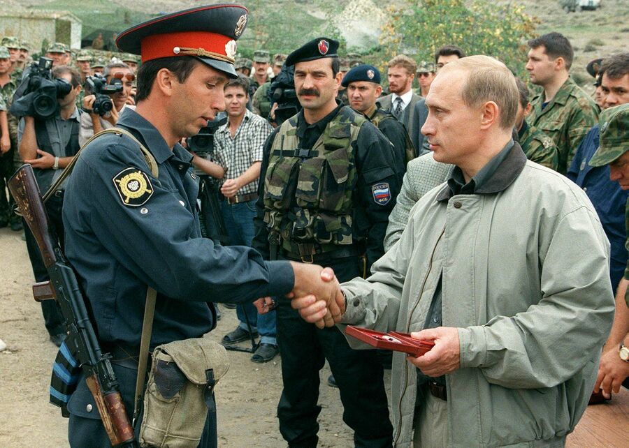 Премьер-министр Владимир Путин вручает награду милиционеру на базе российских войск в горах Ботлихского района в Дагестане 27 августа 1999 года
