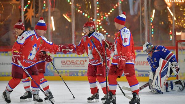 Президент РФ Владимир Путин радуется заброшенной шайбе в предновогоднем товарищеском матче Ночной хоккейной лиги на катке на Красной площади