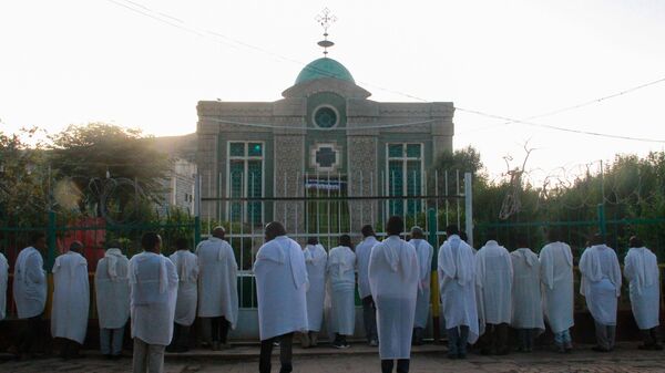 Эфиопские христиане молятся у ворот храма Девы Марии Сионской, где хранится Ковчег Завета. Аксум, Эфиопия
