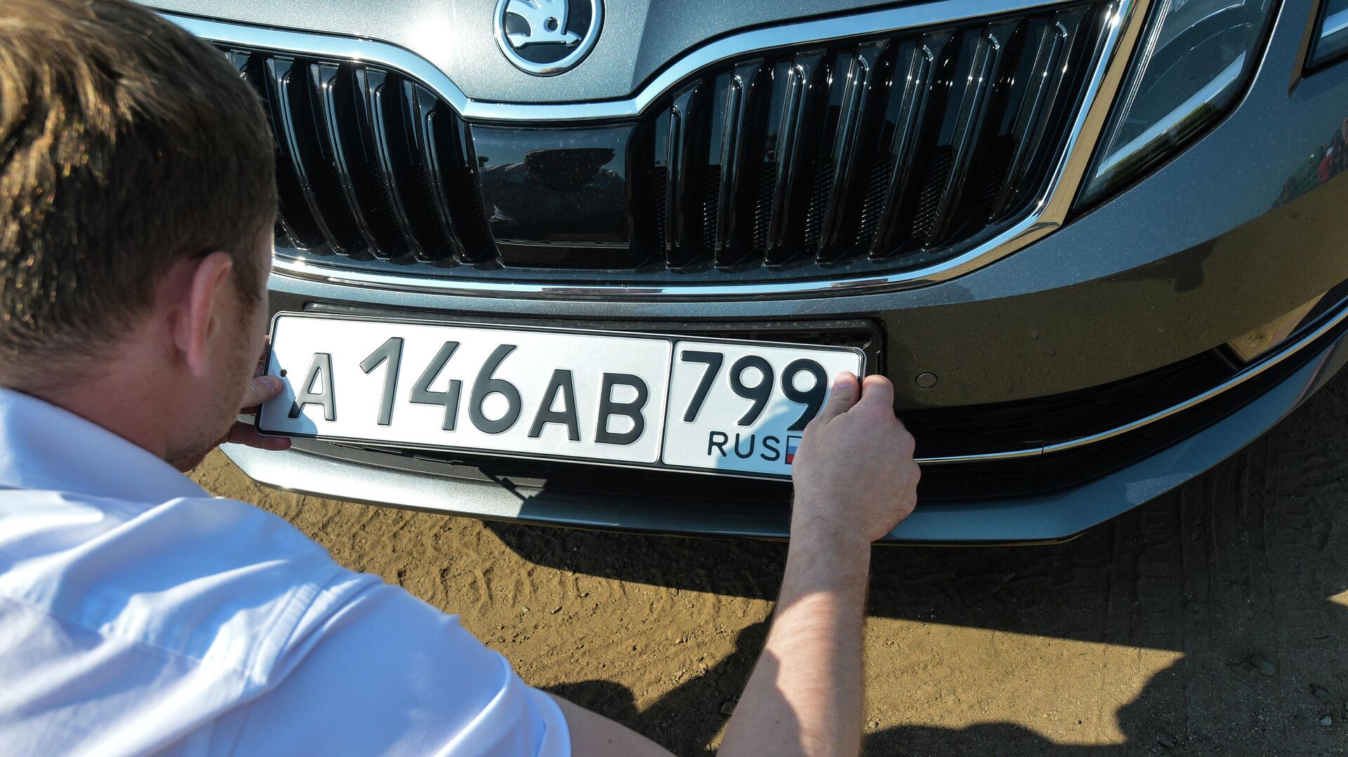 Автовладелец устанавливает номерной знак на автомобиль  - РИА Новости, 1920, 13.09.2020