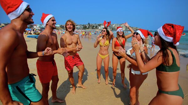 Туристы в рождественских костюмах на пляже в Сиднее