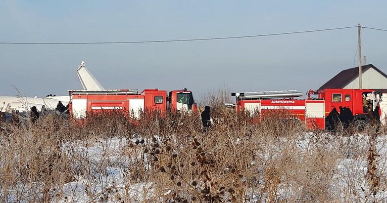 Сотрудники спасательной службы и полиции работают на месте крушения самолета Fokker 100 казахстанской авиакомпании Bek Air