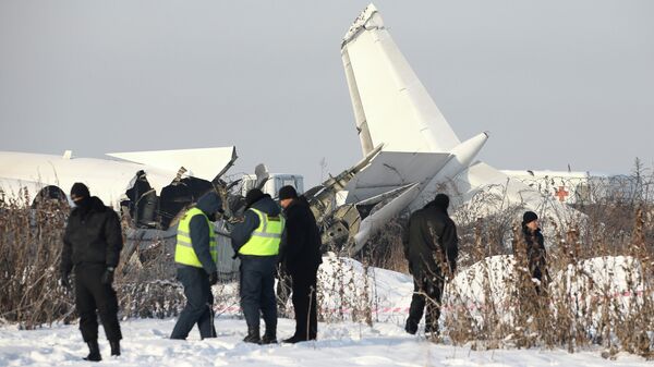 Сотрудники спасательной службы и полиции работают на месте крушения самолета Fokker 100 казахстанской авиакомпании Bek Air