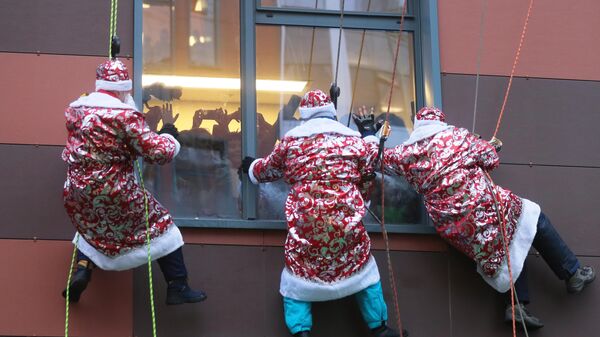 Сотрудники департамента по делам гражданской обороны, чрезвычайным ситуациям и пожарной безопасности города Москвы в костюмах Дедов Морозов поздравляют пациентов Морозовской детской больницы