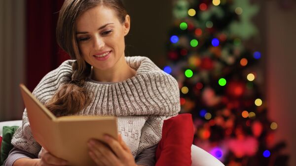Девушка читает книгу у рождественской елки