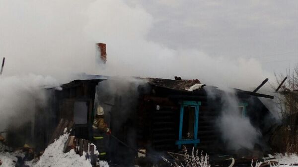 Сотрудники МЧС во время тушения пожара в доме в деревне Сидорята Пермского края. 28 декабря 2019