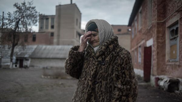 Женщина во дворе дома в поселке Гольмовский Донецкой области