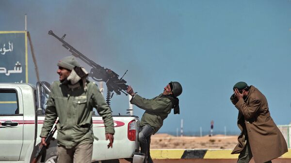Боец оппозиции стреляет из пулемета в истребитель в городе Рас-Лануф в Ливии