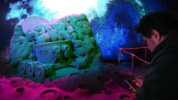 Посетитель в павильоне Песочной скульптуры на V Новогоднем фестивале Ледовая Москва. В кругу семьи в Парке Победы на Поклонной горе