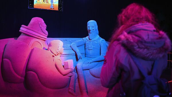 Посетитель в павильоне Песочной скульптуры на V Новогоднем фестивале Ледовая Москва. В кругу семьи в Парке Победы на Поклонной горе