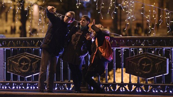 Люди фотографируются на Дворцовом мосту в Санкт-Петербурге в новогоднюю ночь