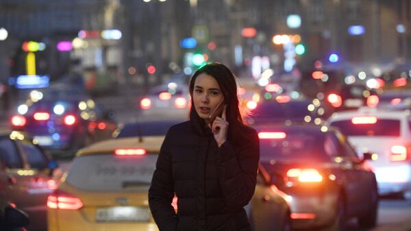 Девушка идет вдоль проезжей части  в Москве.