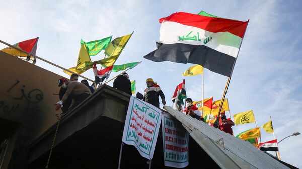 Сторонники сил народной мобилизации Ирака во время демонстрации против нанесения авиаударов у посольства США в столице Ирака Багдаде. 1 января 2020