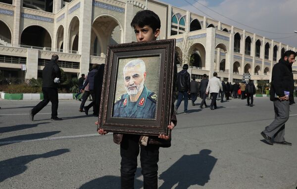 Мальчик несет портрет Касема Сулеймани, убитого во время авиаудара США в Ираке