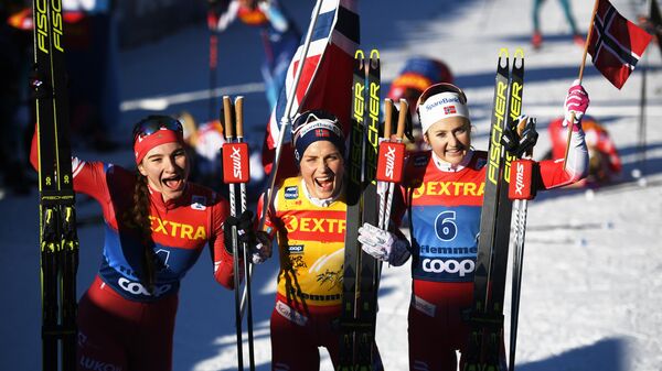 Слева направо: Наталья Непряева (Россия), занявшая второе место, Тереза Йохауг (Норвегия), занявшая первое место, Ингвильд Остберг (Норвегия), занявшая третье место в общем зачете на соревнованиях по лыжным гонкам Тур де Ски в итальянском Валь-ди-Фьемме.