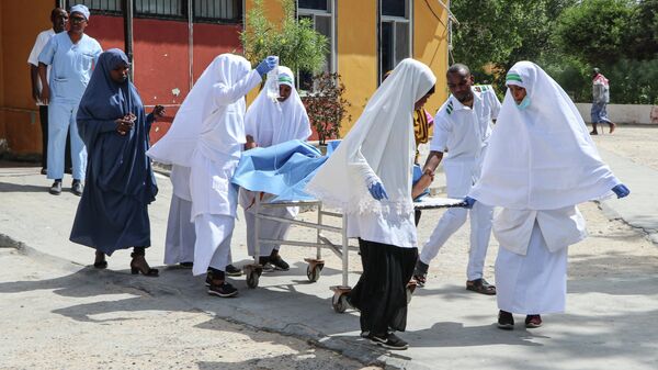 Медики несут пострадавшего в результате взрыва автомобиля в Могадишо, Сомали. 8 января 2020