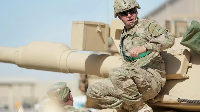 Сержант-механик армии США осматривает танк Абрамс M1A2 во время учений в лагере Арифжан, Кувейт