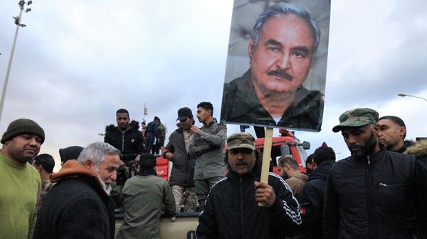 Люди с портретом генерала Халифы Хафтара во время демонстрации в Бенгази против вмешательства Турции и в поддержку признанного ООН правительства в Триполи