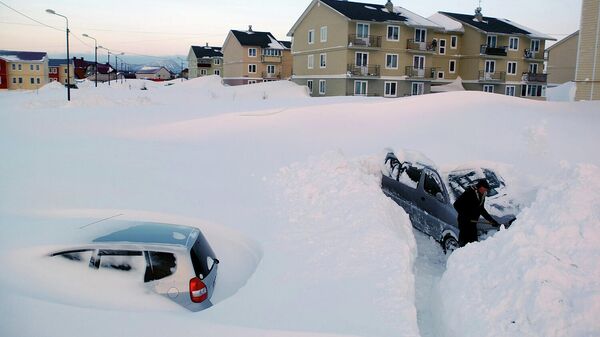 Житель села Троицкое Анивского района Сахалинской области откапывает свой автомобиль от снега