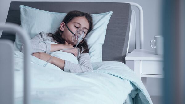 Девочка в кислородной маске в больнице