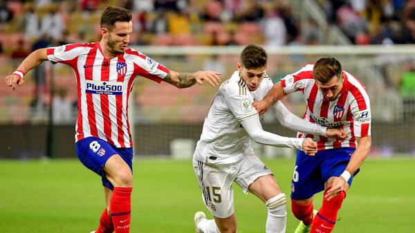 Real Madrid's Uruguayan midfielder Federico Valverde (C) is marked by Atletico Madrid's Spanish midfielder Saul Niguez (L) and Atletico Madrid's Mexican midfielder Hector Herrera during the Spanish Super Cup final between Real Madrid and Atletico Madrid on January 12, 2020, at the King Abdullah Sports City in the Saudi Arabian port city of Jeddah. (Photo by Giuseppe CACACE / AFP)