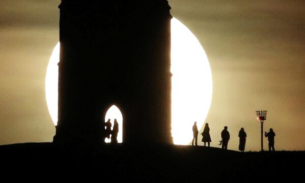 Полная Луна восходит за холмом Святого Михаила в Гластонбери, Великобритания