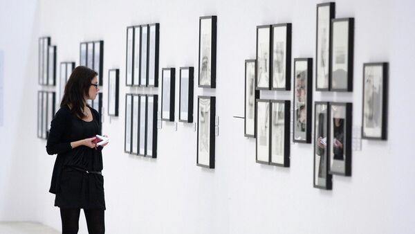 Посетительница осматривает экспозицию на выставке