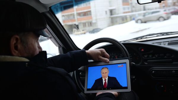 Житель Екатеринбурга смотрит трансляцию ежегодного послания президента РФ Владимира Путина к Федеральному собранию