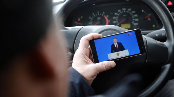 Житель Екатеринбурга смотрит трансляцию ежегодного послания президента РФ Владимира Путина Федеральному Собранию