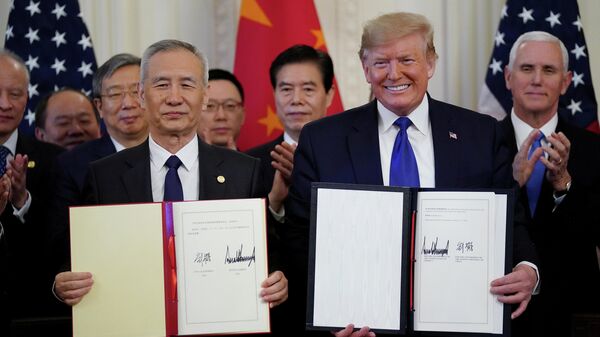 Вице-премьер Китая Лю Хэ и президент США Дональд Трамп после подписания первого пакета документов в рамках торгового соглашения в Вашингтоне. 15 января 2020