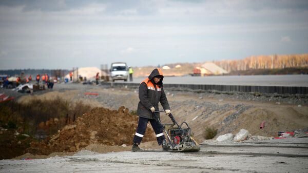 Рабочие на территории строительства взлетной полосы нового сегмента терминала аэропорта Домодедово
