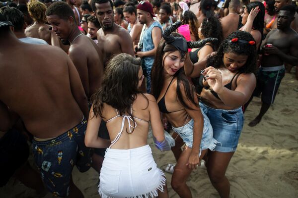 Женщины танцуют во время вечеринки Bloco da Favorita на пляже Копакабана в Рио-де-Жанейро, Бразилия