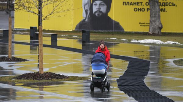 Девушка с коляской гуляет в Парке Горького в Москве