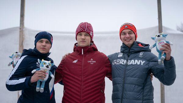 (from L) second-placed Russia's Pavel Repilov, first-placed Austria's Florian Tanzer and third-placed Germany's Timon Grancagnolo posing with the mascot during the podium ceremony after competing in the Luge Men’s Single event on the St Moritz Olympia Bob Run, in Saint Moritz, during the 2020 Lausanne Winter Youth Olympic Games on January 18, 2020. (Photo by Thomas LOVELOCK / OIS/IOC / AFP) / RESTRICTED TO EDITORIAL USE - MANDATORY CREDIT AFP PHOTO / OIS/IOC / Thomas LOVELOCK - NO MARKETING - NO ADVERTISING CAMPAIGNS - DISTRIBUTED AS A SERVICE TO CLIENTS