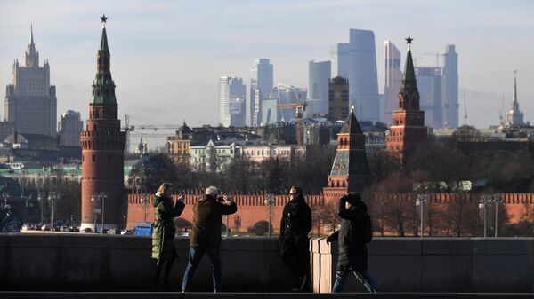 Прохожие фотографируются на Большом Москворецком мосту в Москве