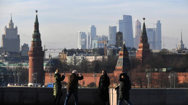 Прохожие фотографируются на Большом Москворецком мосту в Москве. Архивное фото