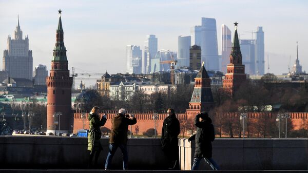 Прохожие фотографируются на Большом Москворецком мосту в Москве