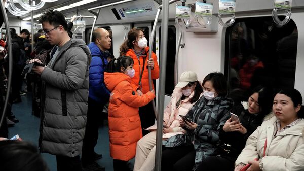 Люди носят маски во время поездки в метро в Пекине, Китай. 21 января 2020