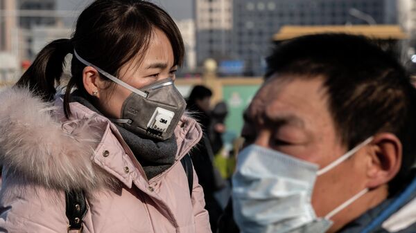 Женщина в защитной маске на железнодорожном вокзале Пекина, откуда множество людей отправляется домой на новогодние праздники. 21 января 2020