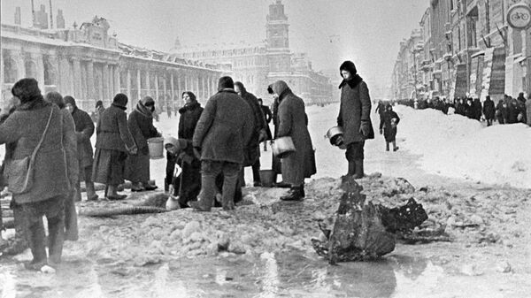 Жители блокадного Ленинграда набирают воду, появившуюся после артобстрела в пробоинах в асфальте Жители блокадного Ленинграда набирают воду, появившуюся после артобстрела в пробоинах в асфальте