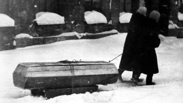 Жители города везут на санках гроб с умершем. Блокада Ленинграда