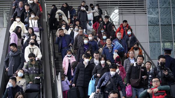 Пассажиры в масках на железнодорожном вокзале в Шанхае
