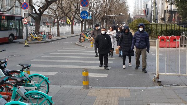 Люди в защитных масках на улице Пекина